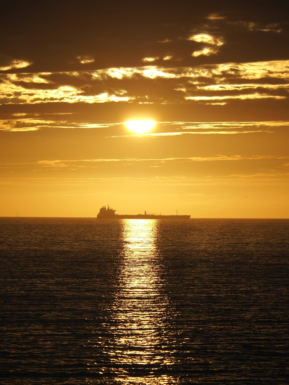 silhouette of ship on sea during sunset