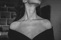 Black and white editorial shot of a female model showcasing subtle, feminine jewelry with an edgy twist.