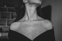 Elegant black and white photo of a woman wearing a simple pendant necklace.