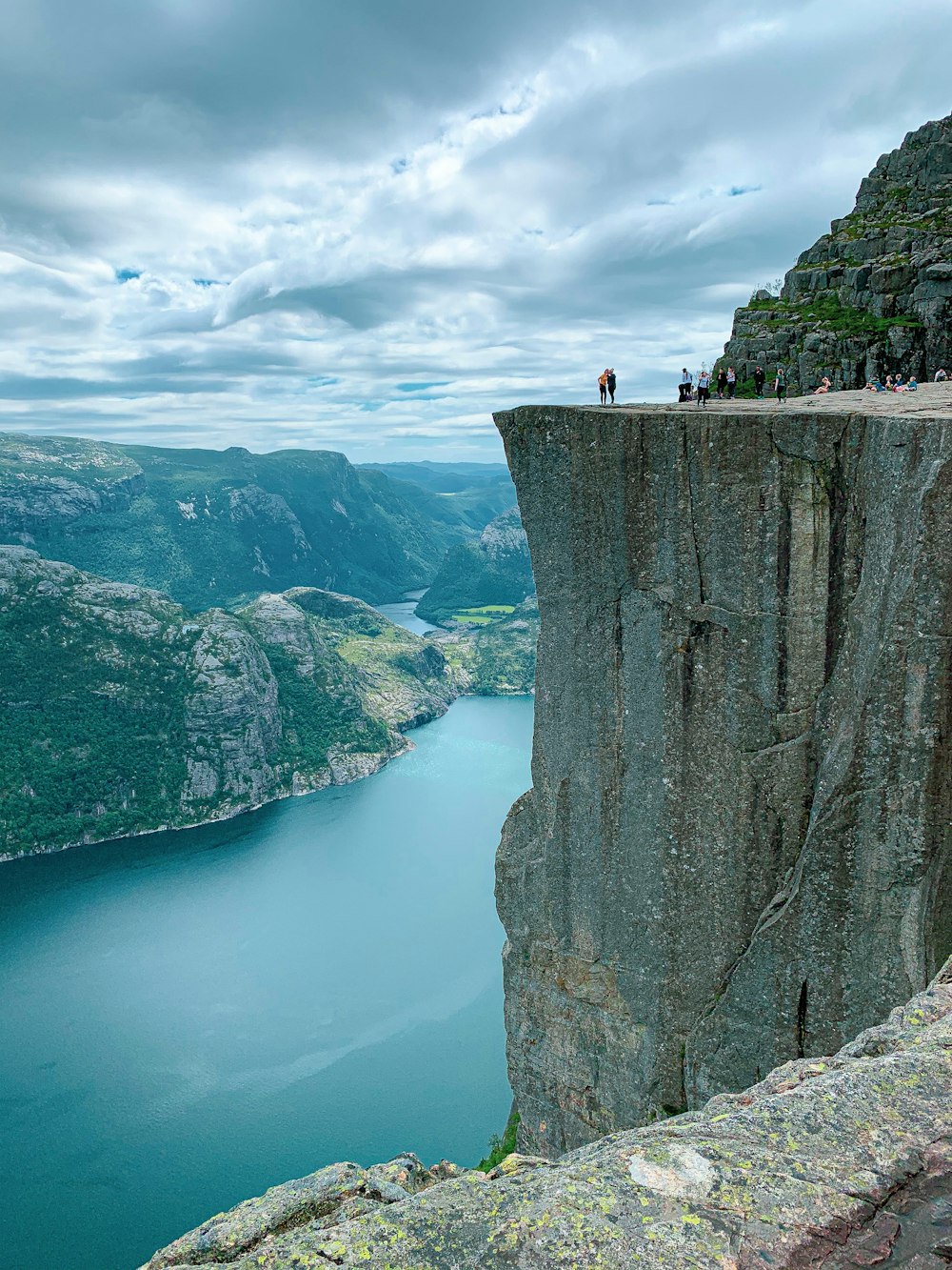 person standing on rock formation near body of water during daytime