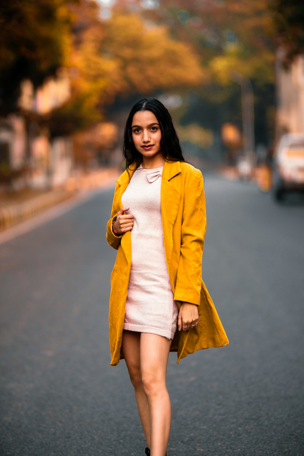 Donna in blazer giallo in piedi sulla strada durante il giorno