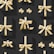 A pattern of variously sized black gift boxes adorned with shiny golden ribbons, arranged neatly against a dark background. The lighting casts subtle shadows, highlighting the gleaming texture of the ribbons.