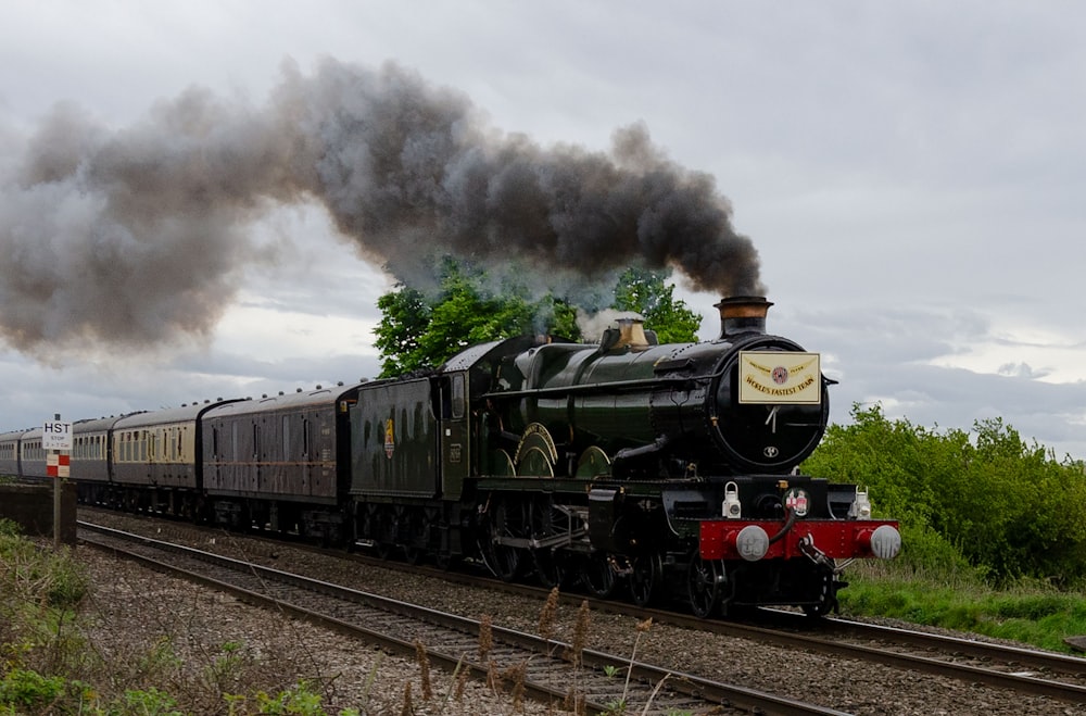 green and black train on rail tracks during daytime