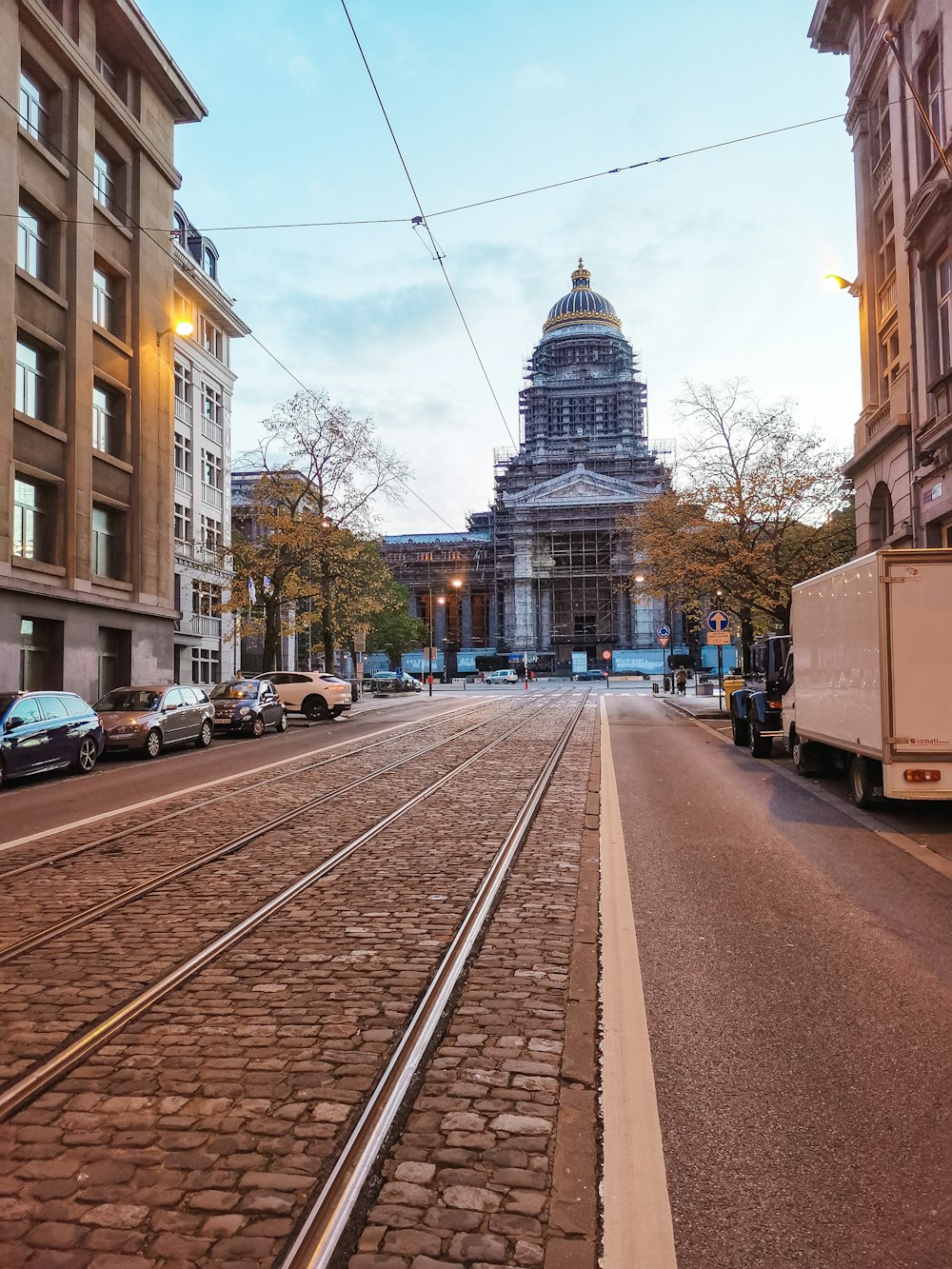 cars parked on side of road near buildings during daytime