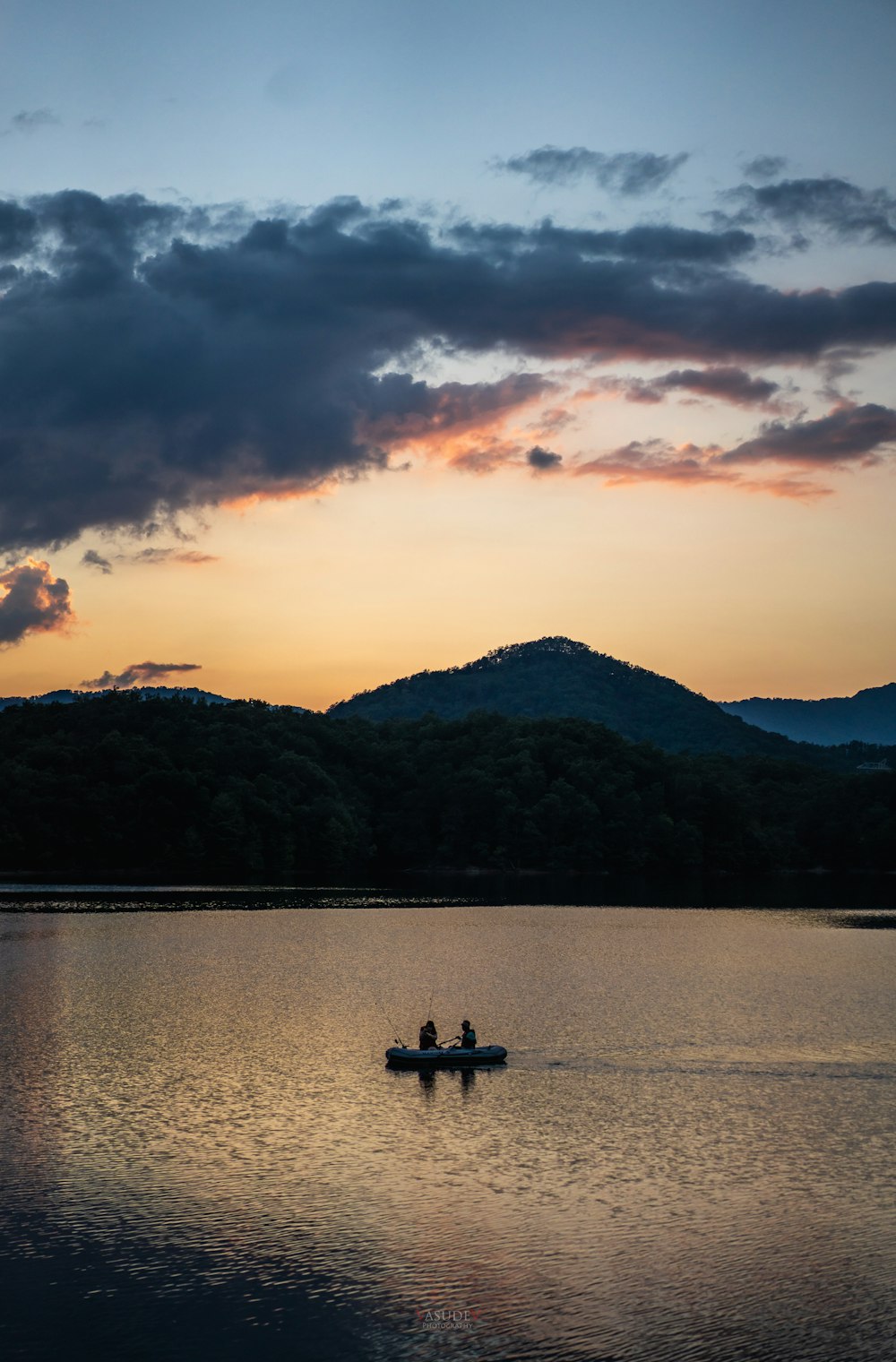 silhouette di persone che cavalcano la barca sul lago durante il tramonto