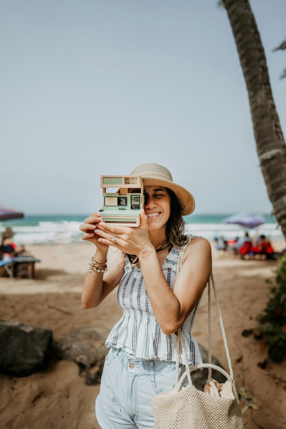 woman in white and blue stripe dress holding white and black camera