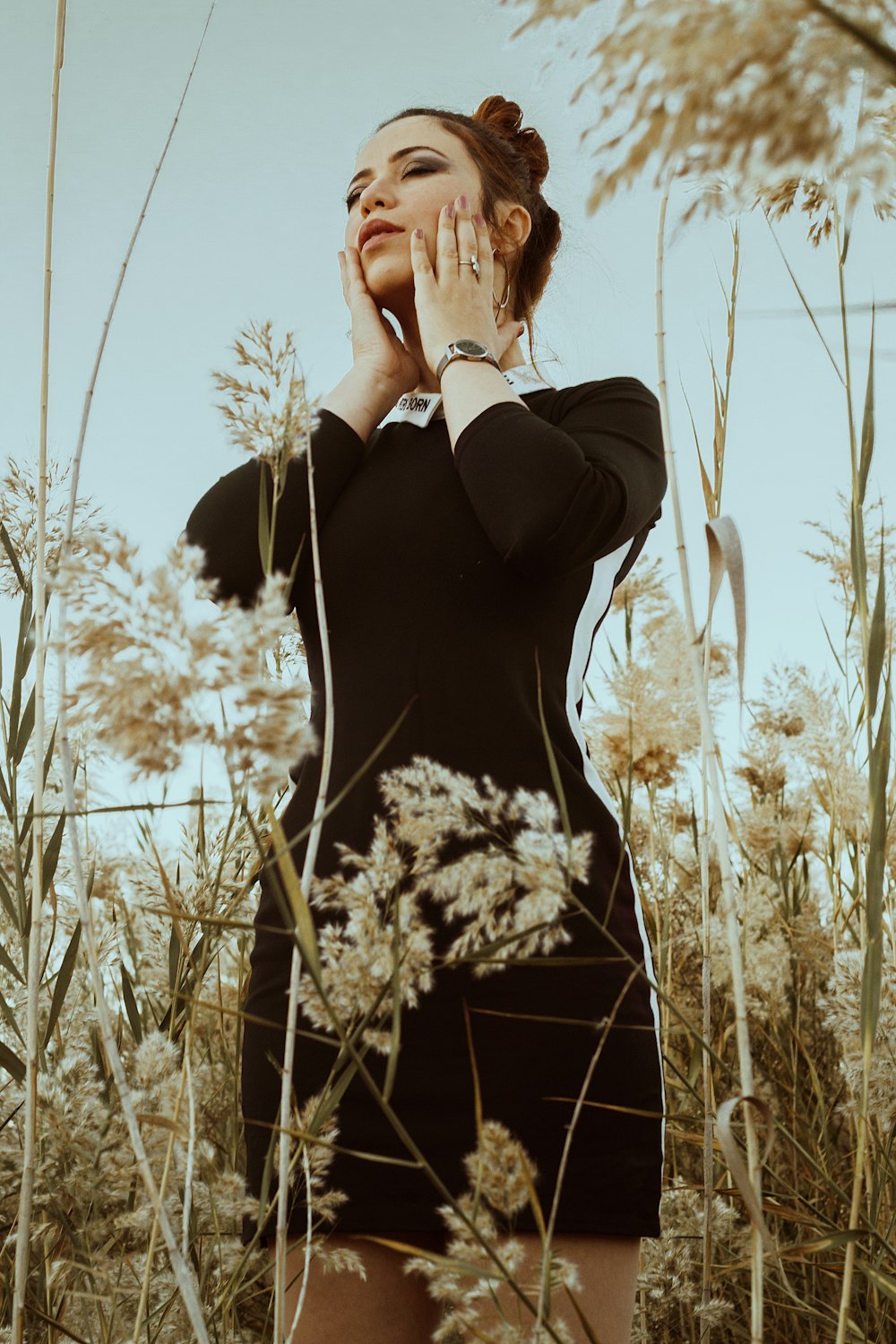 woman in black long sleeve shirt standing on brown grass field during daytime