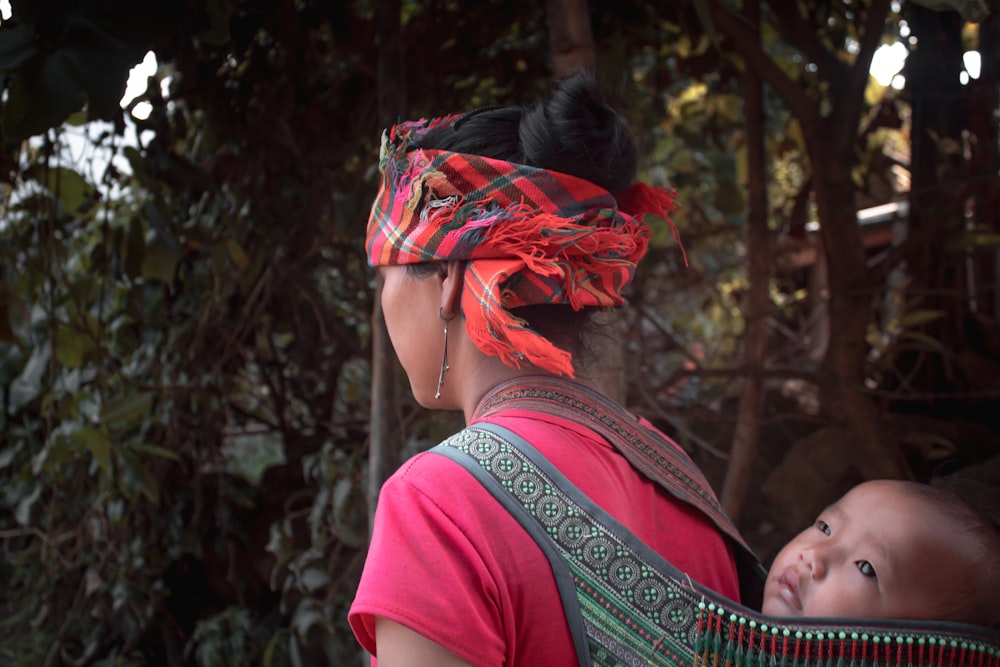 woman in red shirt with green and red floral headdress