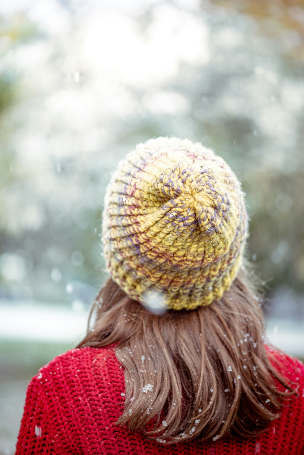 woman in red shirt wearing yellow knit cap