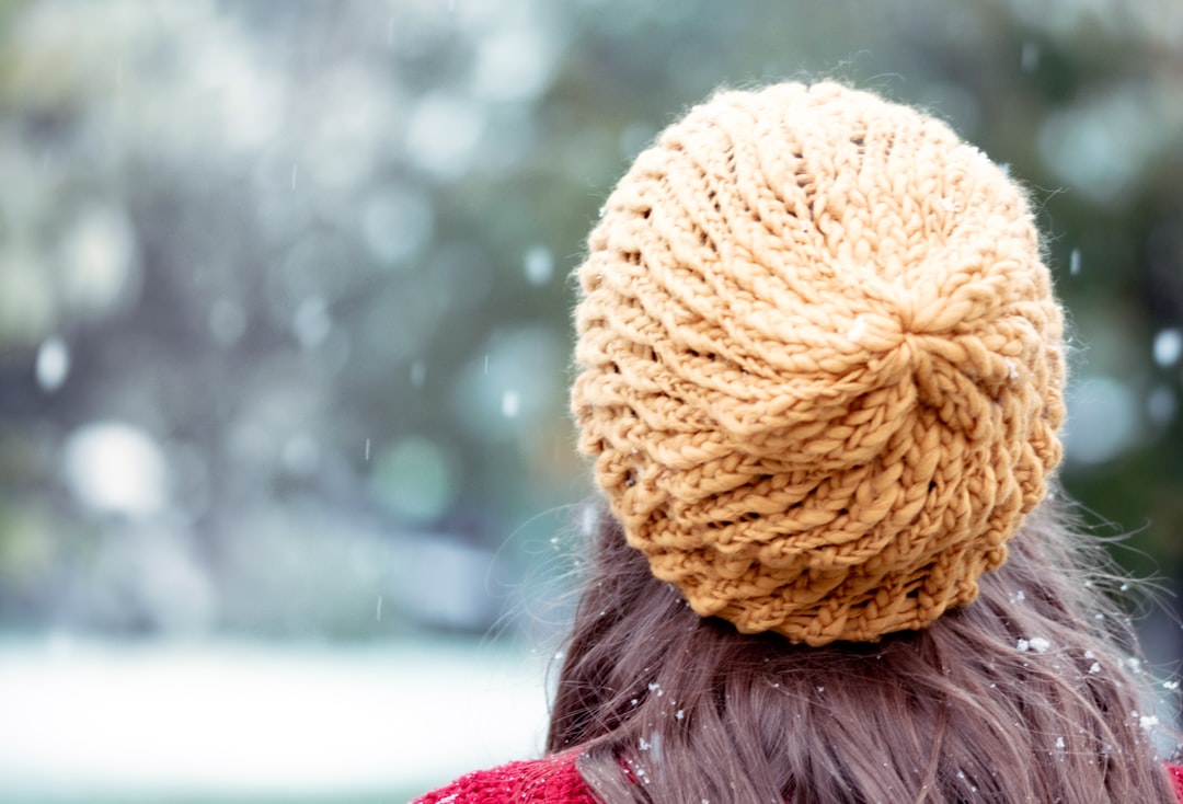 woman in brown knit cap and red shirt