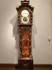 Before and after shots showing the restoration of a vintage grandfather clock’s wooden case.