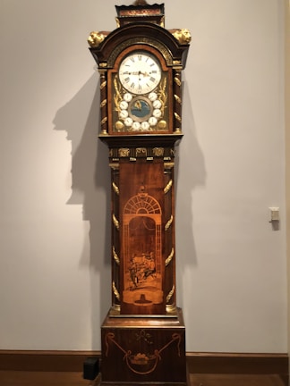A close-up of a classic grandfather clock with polished wood finish.