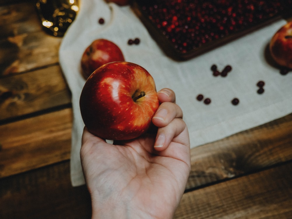 Persona sosteniendo una manzana roja