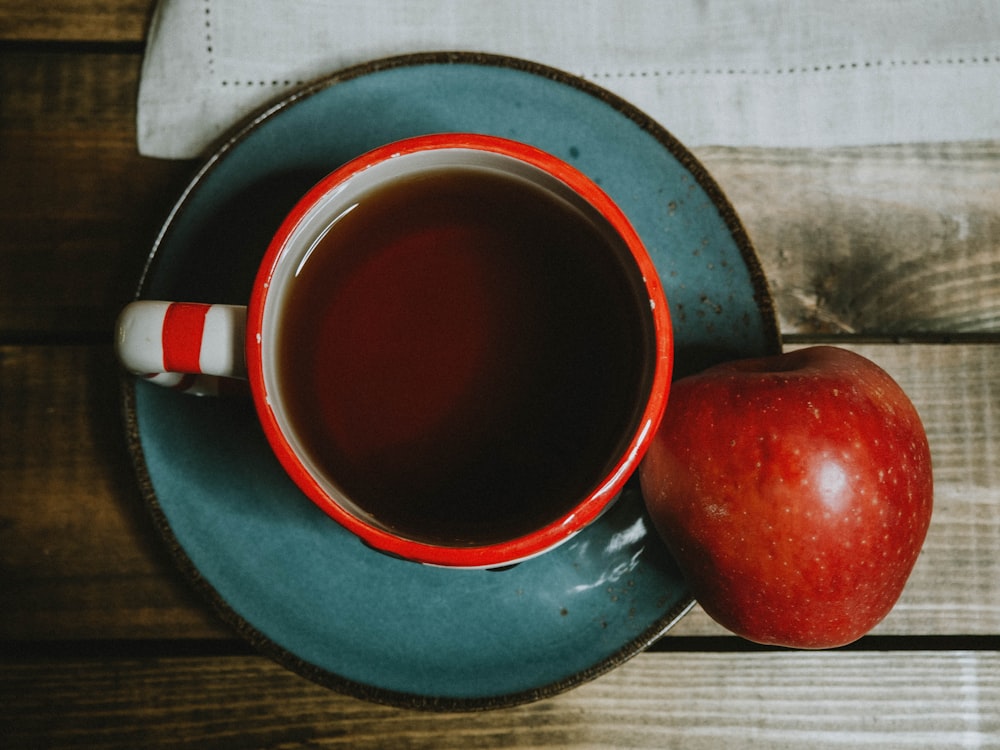 Pomme rouge sur tasse en céramique bleue