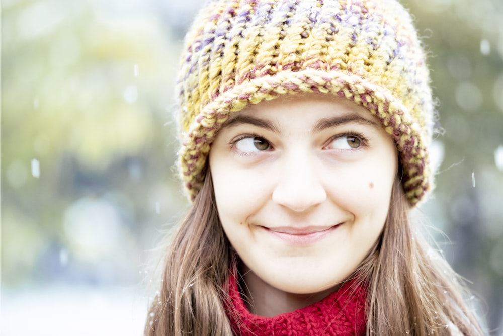 woman in red scarf and brown knit cap