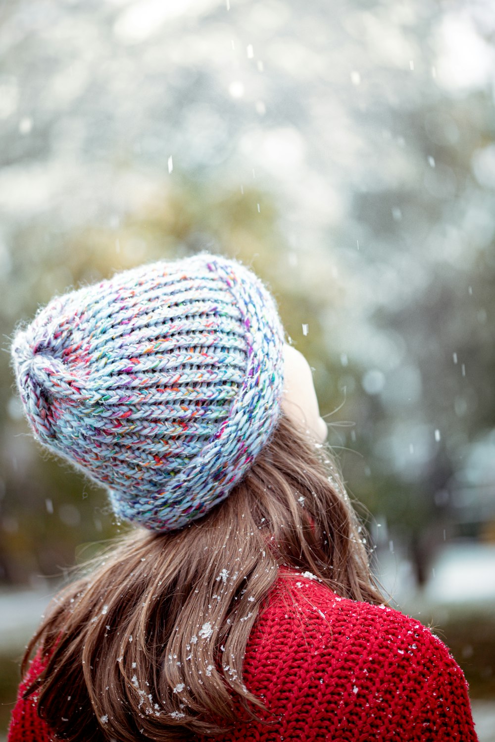 woman in blue knit cap and red jacket