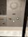 A display case contains a collection of elegant jewelry pieces, including a large gold and gemstone necklace, brooches, and decorative belt buckles. The jewelry is arranged neatly on a gray background with accompanying informational labels beneath each piece.
