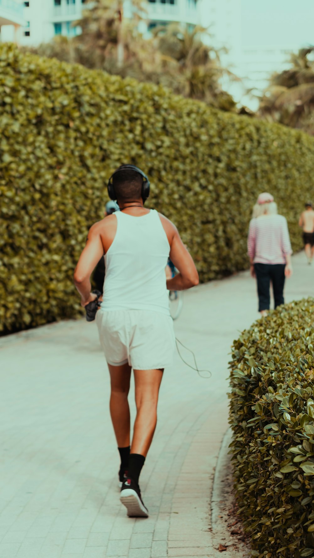 woman in white tank top and white shorts holding black dslr camera