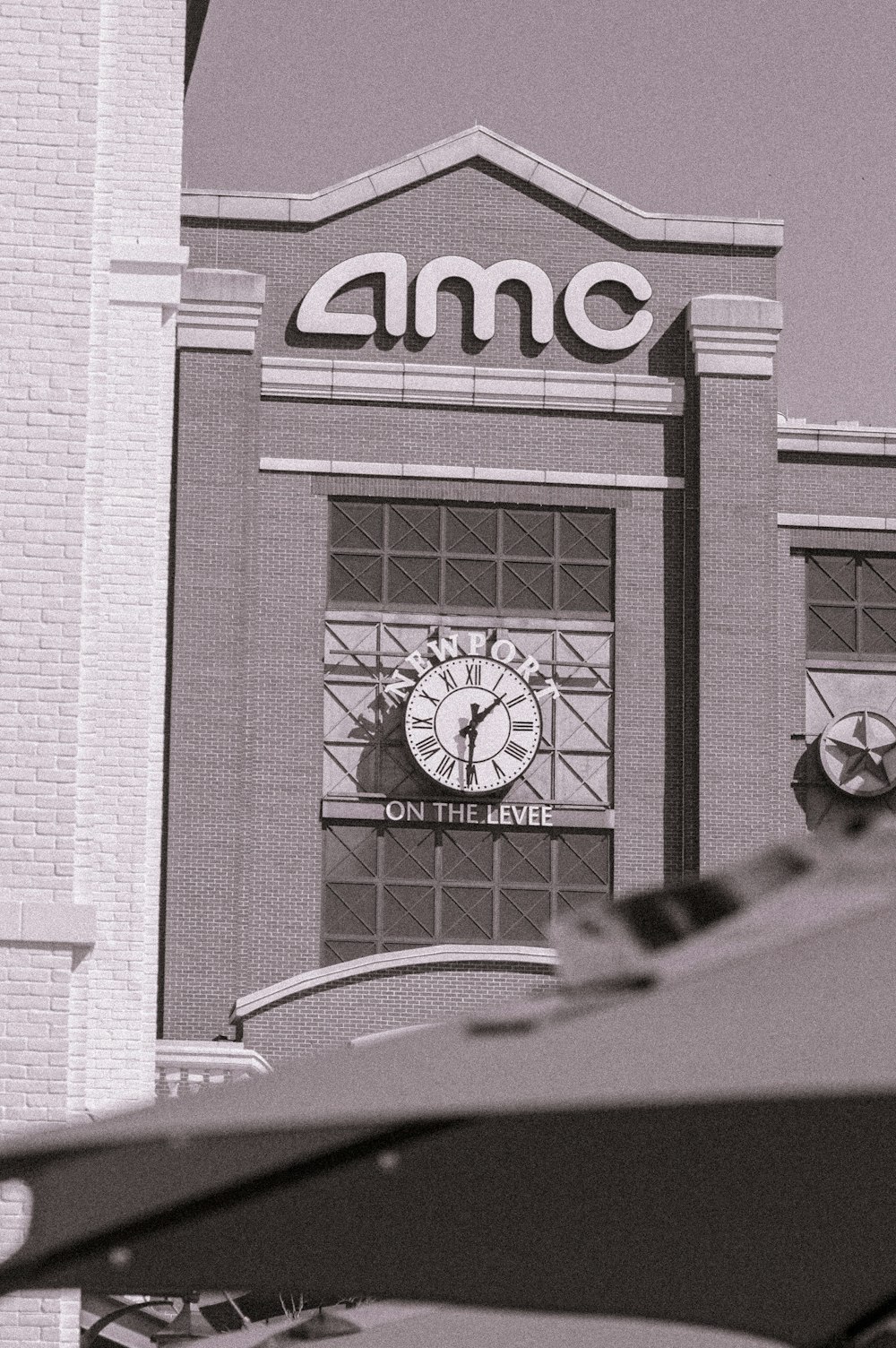 grayscale photo of car parked beside building