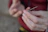 Close-up of hands gently holding a wooden hapé pipe with natural greenery softly blurred in the background.