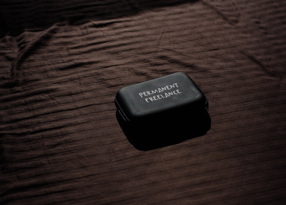 black plastic container on brown wooden table