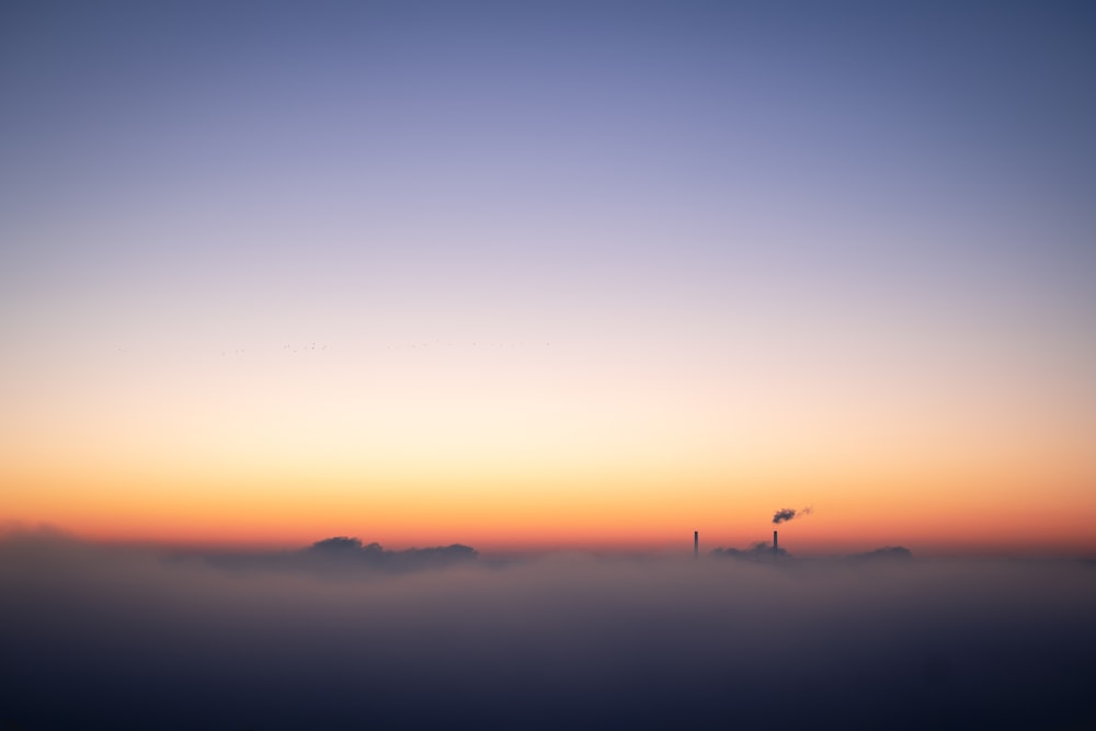 silhouette of person standing on hill during sunset