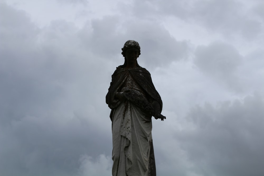 statue of man under cloudy sky during daytime