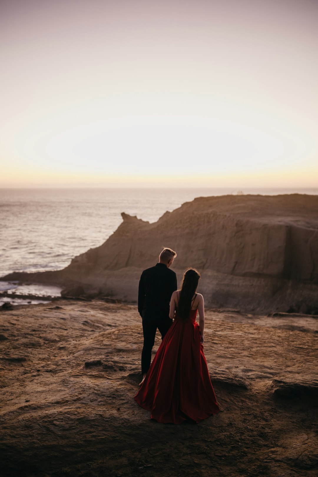 man and woman standing on beach shore during daytime