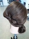 A stylish short haircut on a mannequin head in a salon setting.