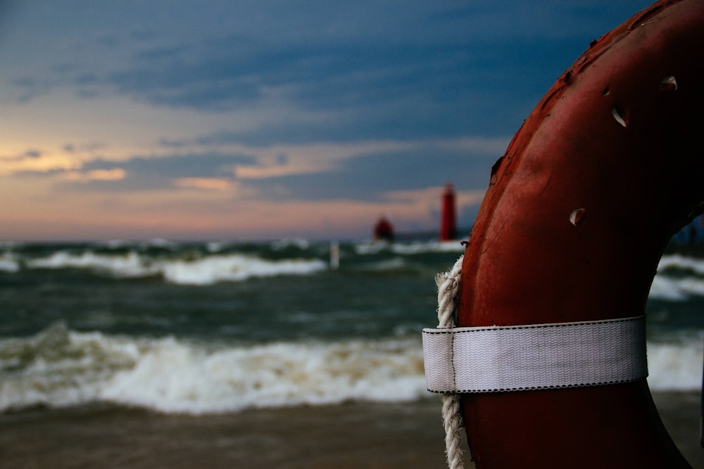 anillo inflable rojo y blanco en la orilla de la playa durante el día