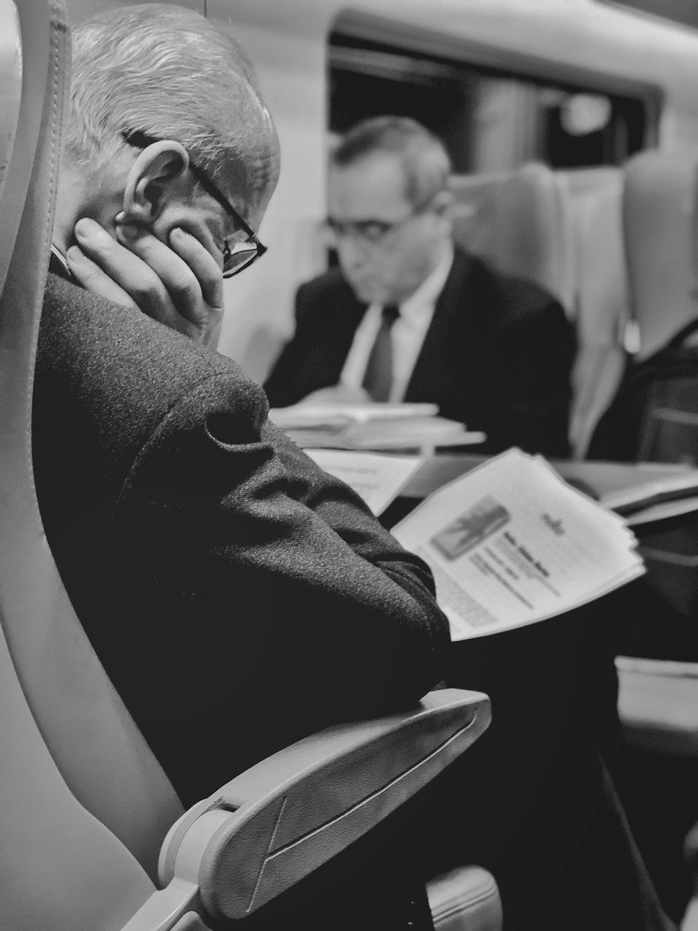 man in black suit jacket reading book