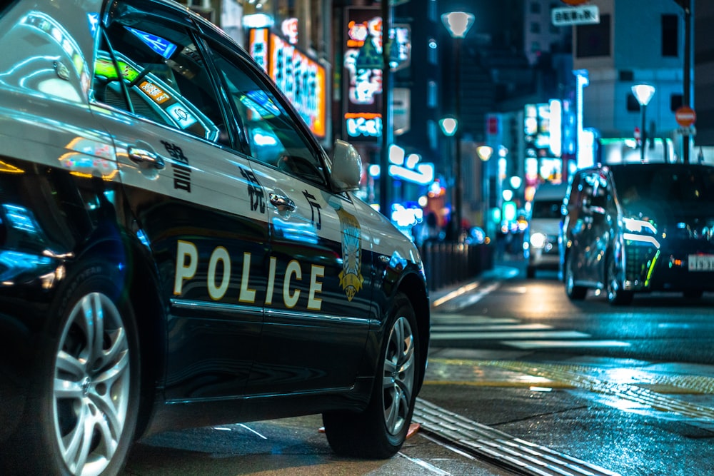 Coche de policía azul y blanco en la carretera durante la noche