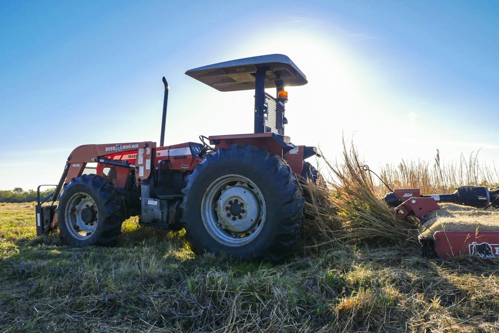 blue and red tractor on green grass field under blue sky during daytime