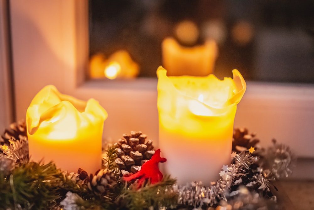 yellow pillar candle on brown wooden table