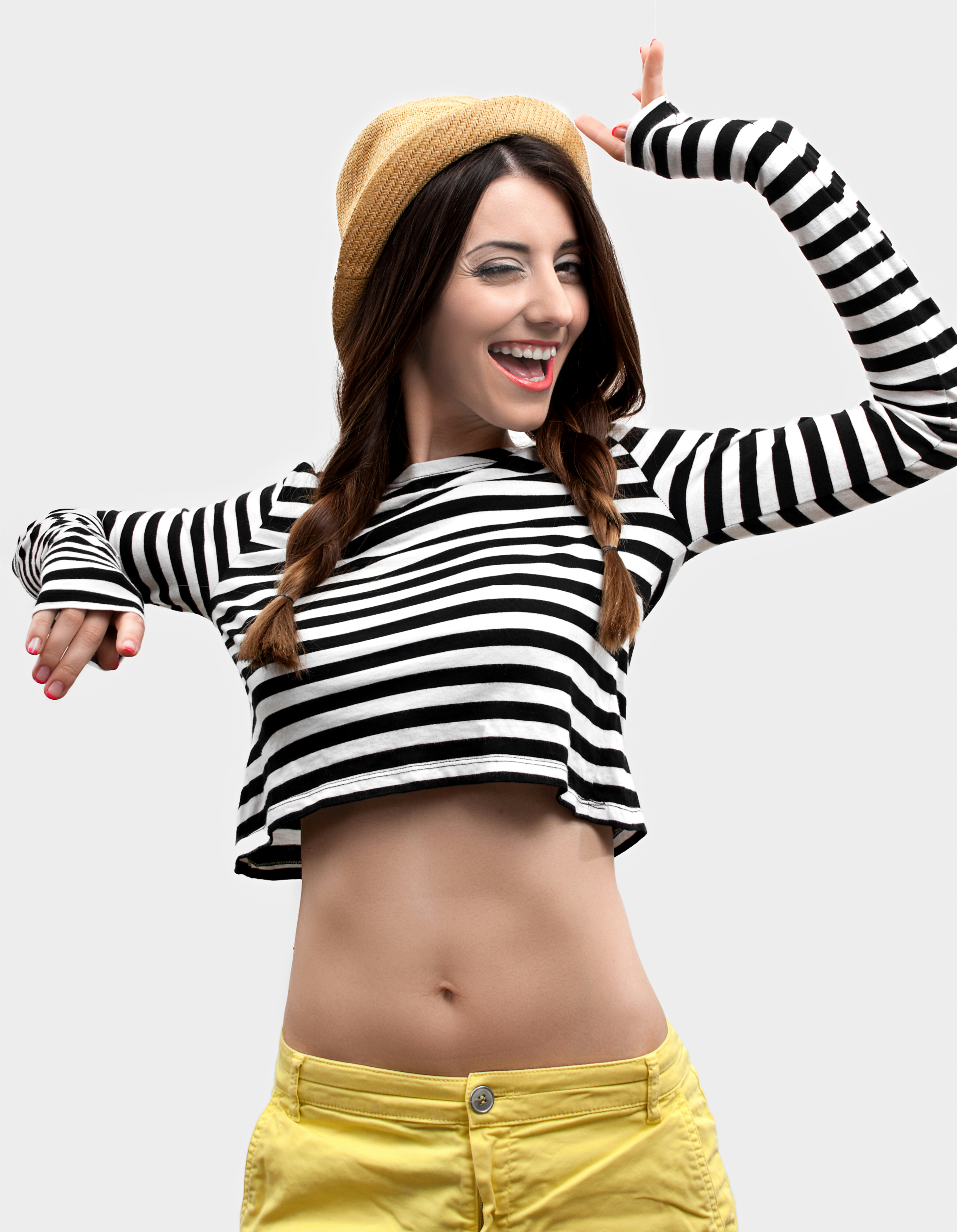Wanita dengan crop top lengan panjang bergaris hitam dan putih dan celana pendek kuning