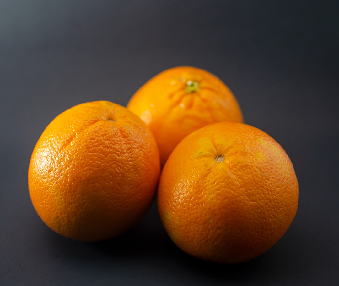 2 orange fruit on black surface