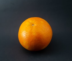 A simple, low-effort illustration of an orange fruit with a quirky smile.