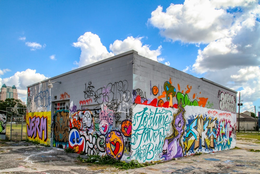 white and blue graffiti on wall under blue sky during daytime