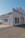 A vintage auto repair building with large lettering on the facade indicating 'Borradori Garage' and 'Auto Repairing'. The structure is painted white with a slightly weathered appearance. There are large windows on the side and peeling paint on the door, suggesting age and use.