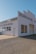 A vintage auto repair building with large lettering on the facade indicating 'Borradori Garage' and 'Auto Repairing'. The structure is painted white with a slightly weathered appearance. There are large windows on the side and peeling paint on the door, suggesting age and use.
