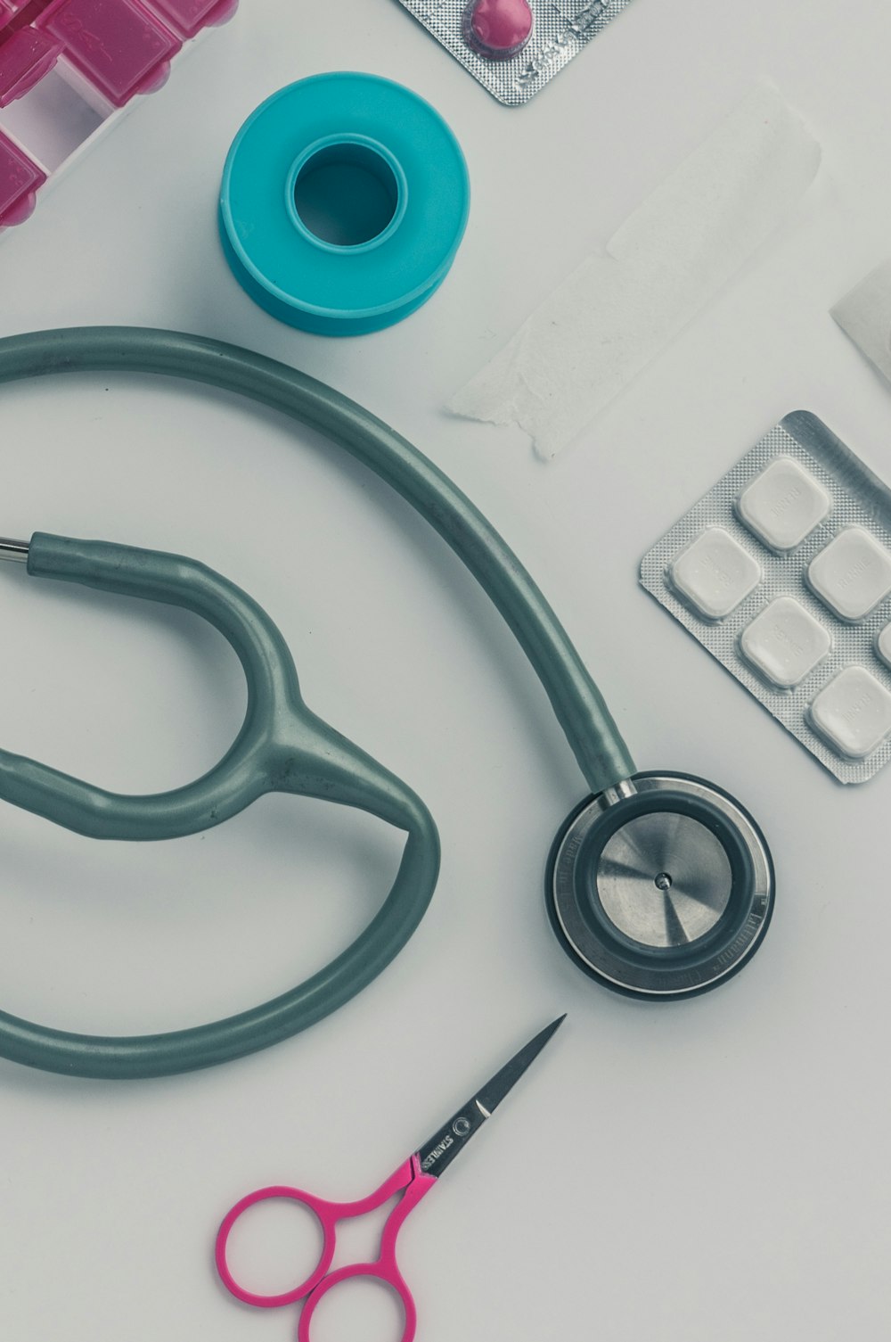 green and silver stethoscope on white plastic table