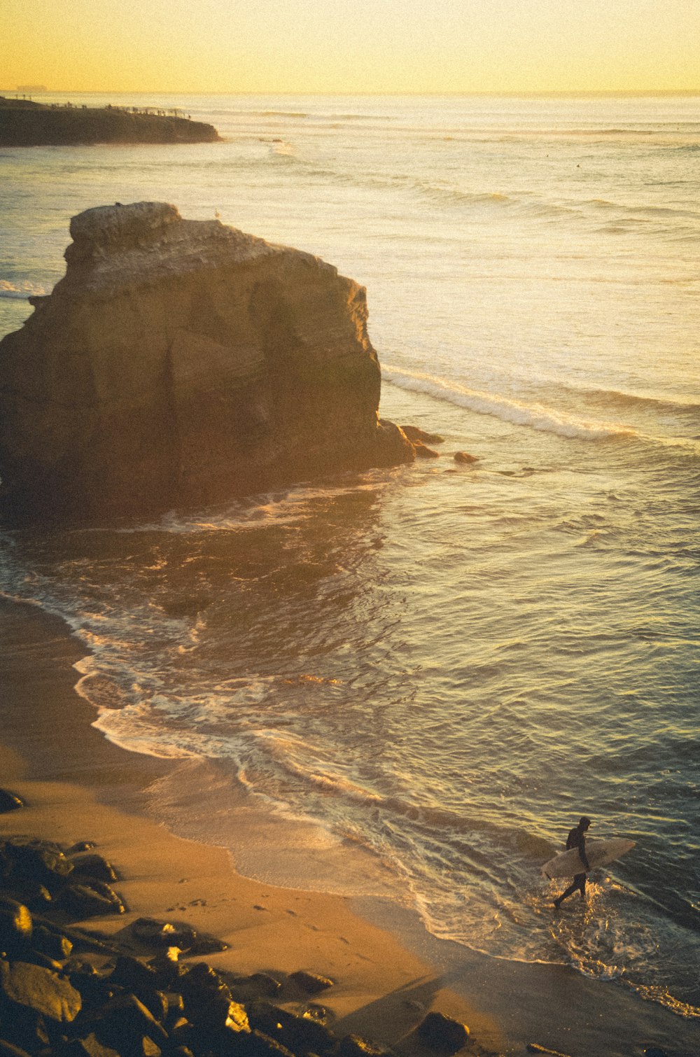 person standing on brown rock formation on sea during daytime