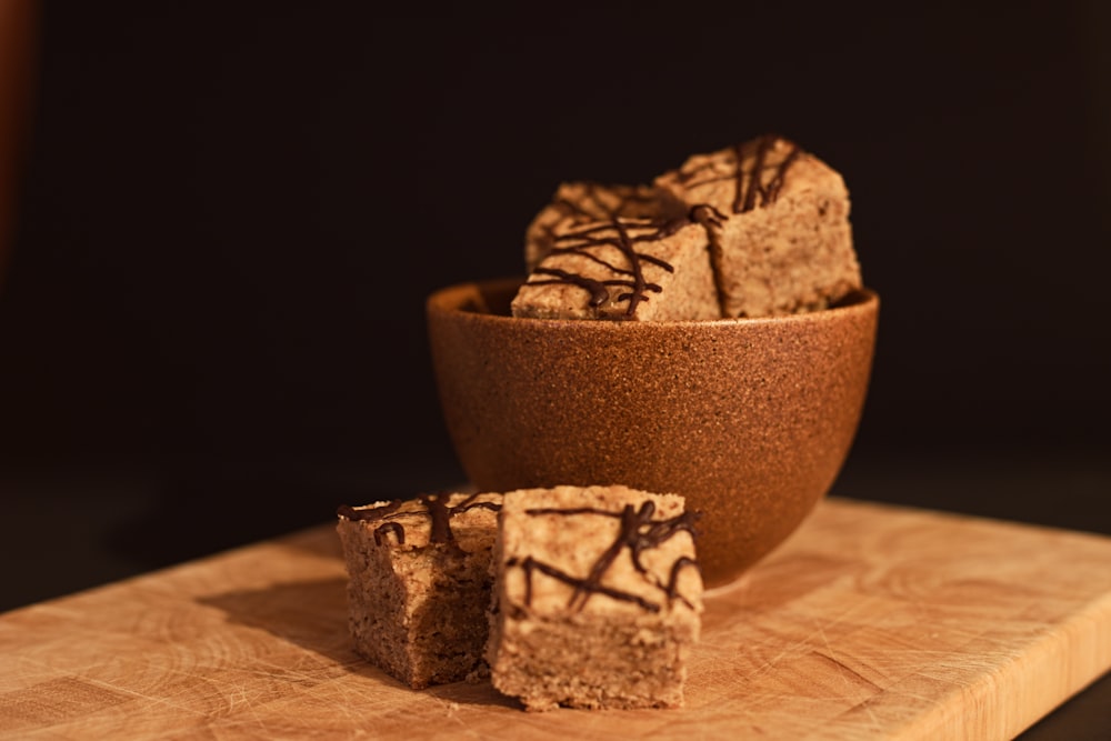 brown and black ceramic bowl on brown wooden table