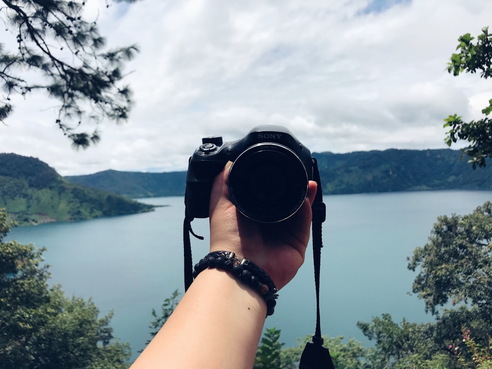 person holding black dslr camera