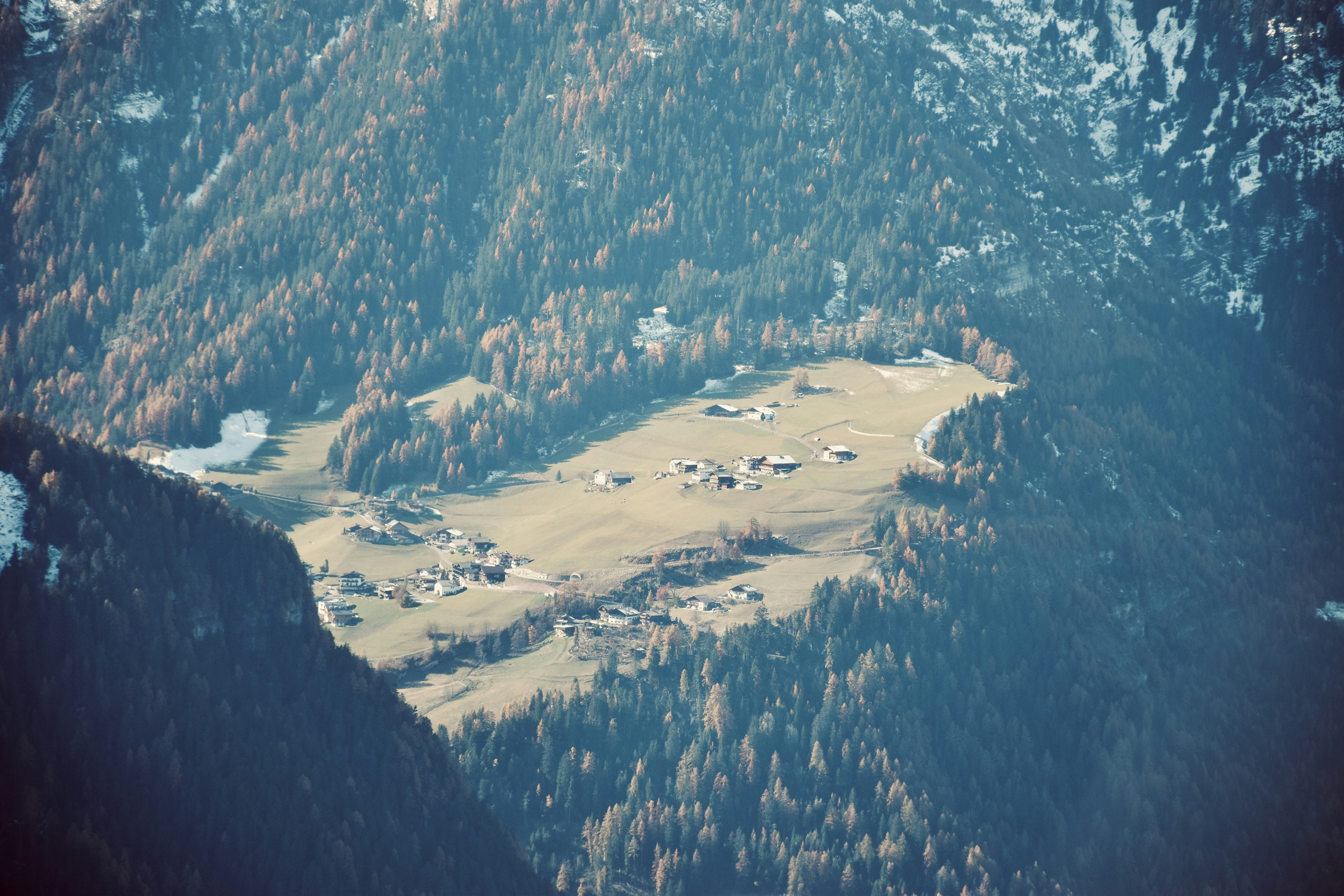 aerial view of green trees and mountains during daytime, Remote alpine village in the Dolomites as seen in late October.