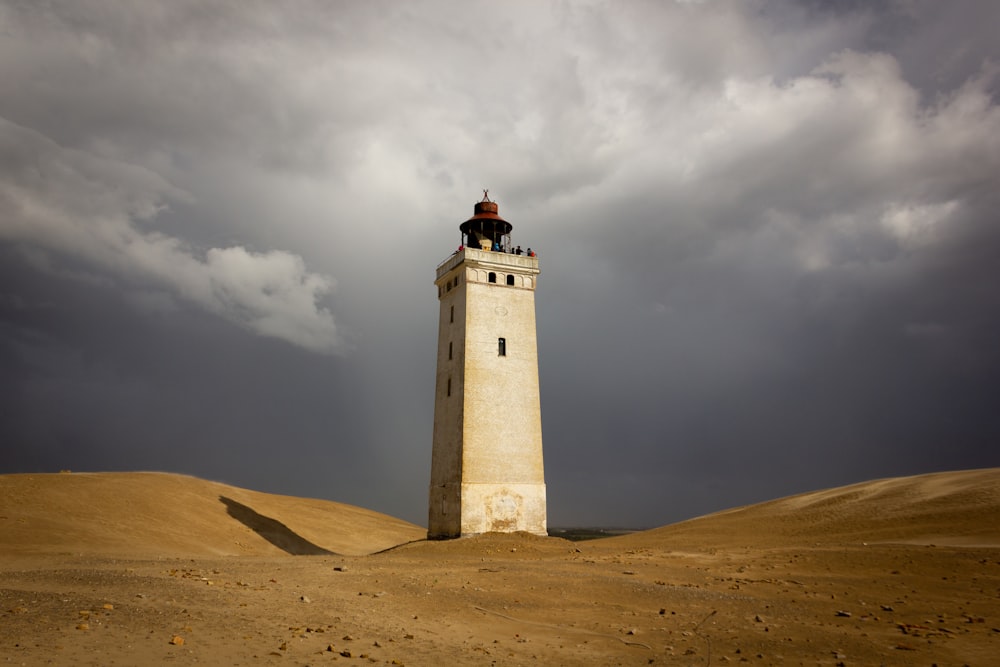 white lighthouse under cloudy sky during daytime