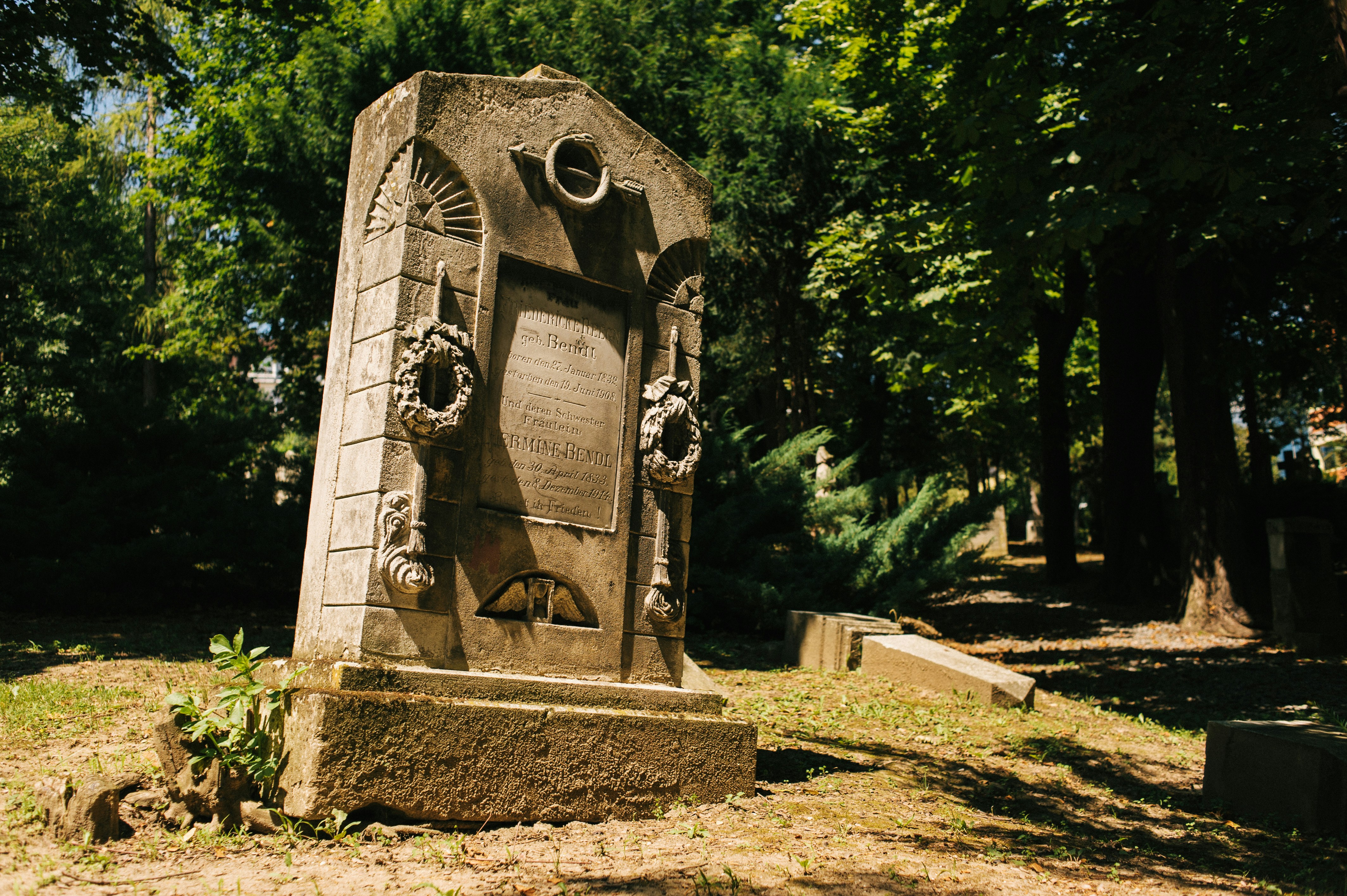 gray concrete statue near green trees during daytime