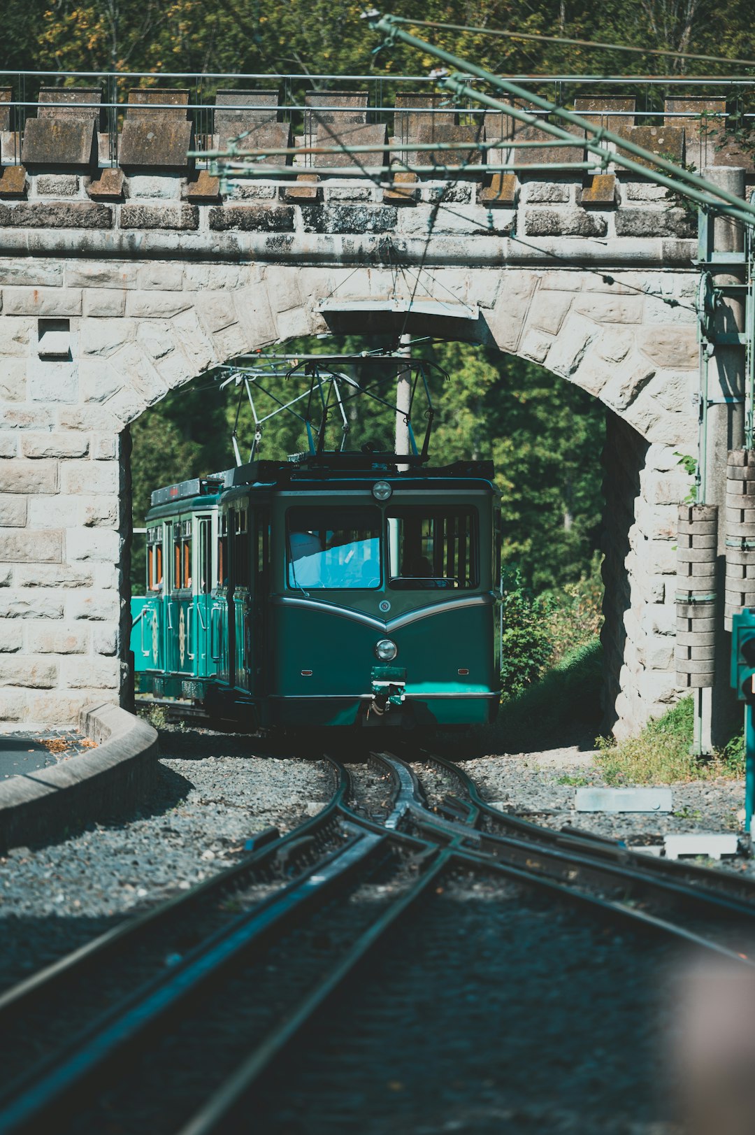 green train on rail tracks