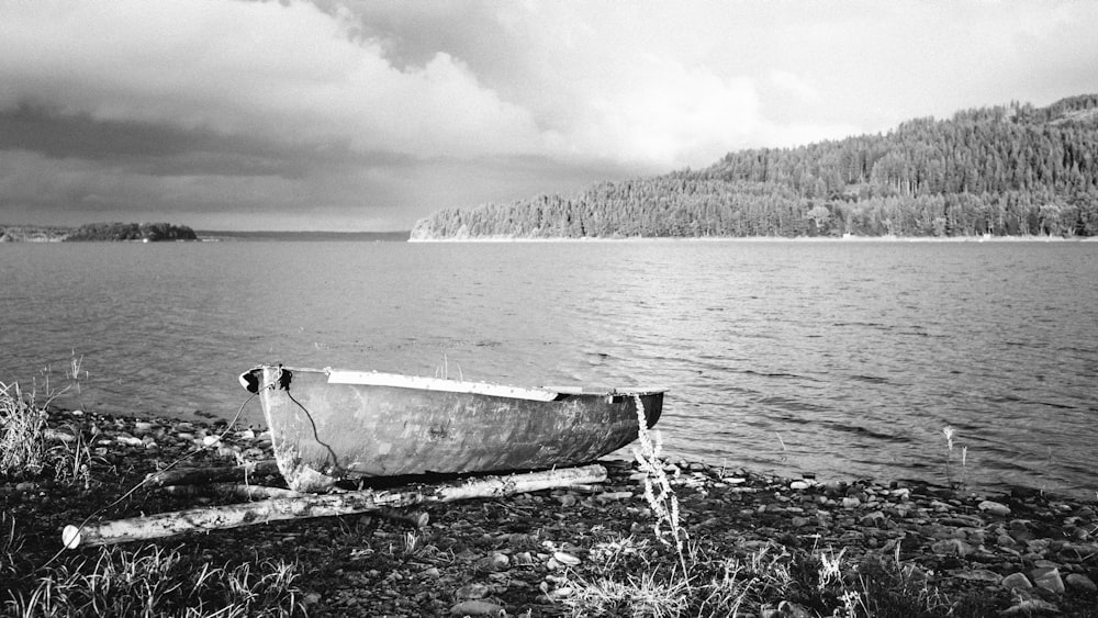 Photo en niveaux de gris d’un canoë sur un plan d’eau