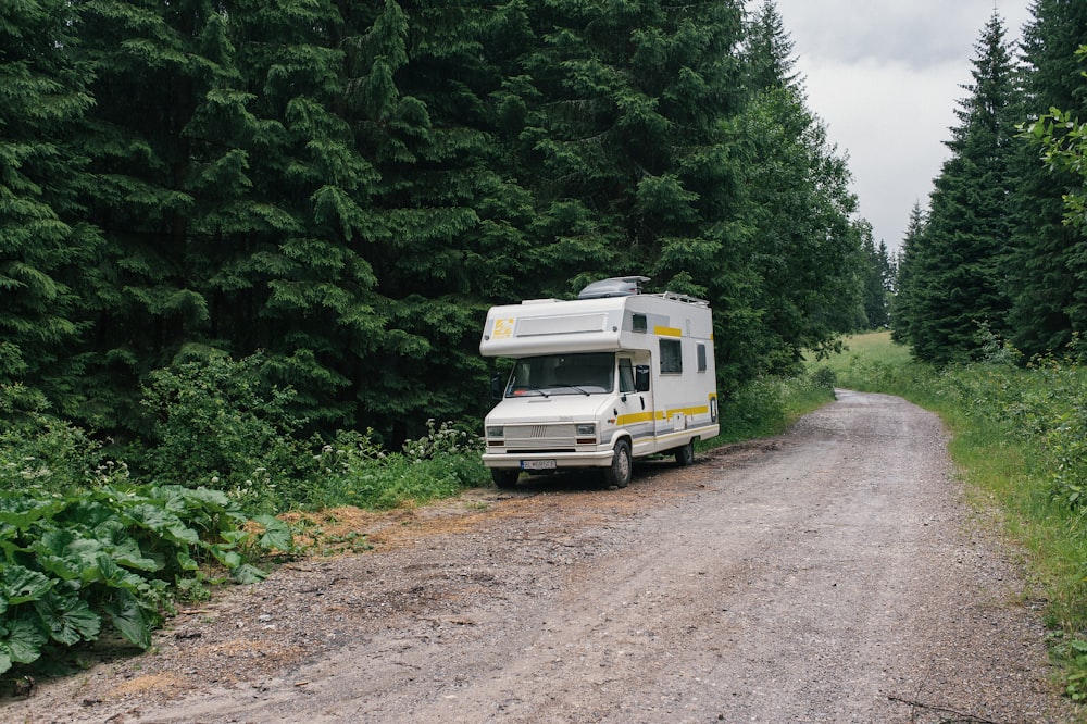 Camping-car blanc et vert sur un chemin de terre